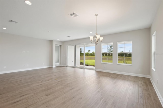 unfurnished room featuring a chandelier, baseboards, recessed lighting, and light wood finished floors