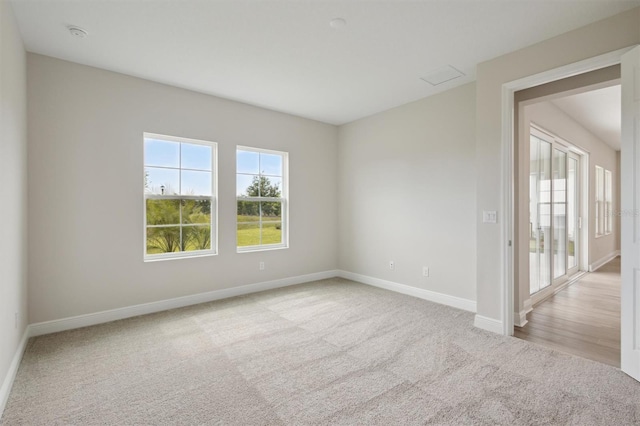 empty room with carpet flooring, baseboards, and a smoke detector