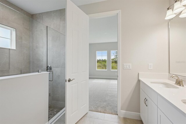 bathroom featuring a shower stall, tile patterned flooring, baseboards, and double vanity