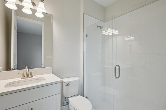 bathroom featuring a shower stall, toilet, and vanity