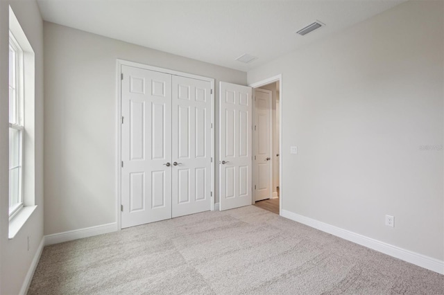 unfurnished bedroom with carpet floors, baseboards, and a closet