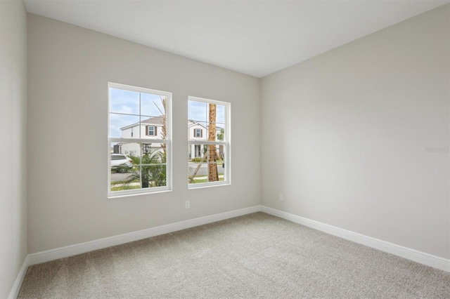 carpeted spare room with baseboards