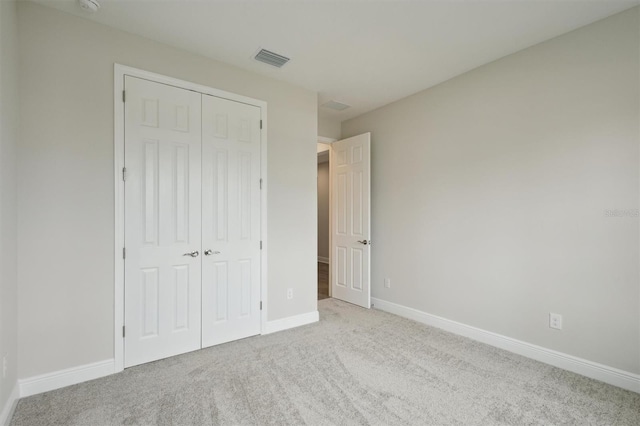 unfurnished bedroom with carpet floors, a closet, and baseboards