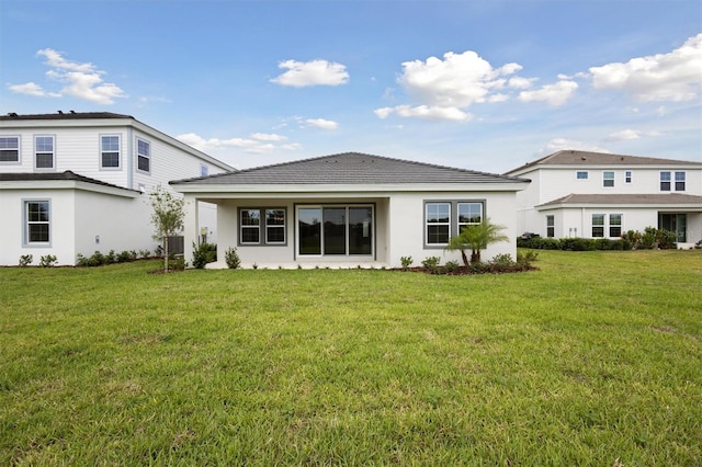 rear view of house with a yard, stucco siding, and cooling unit