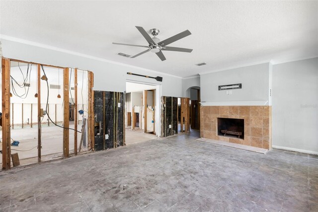 106 13th Ave, St Pete Beach, FL 33706 - unfurnished living room with a tiled fireplace, ornamental molding, ceiling fan, and arched walkways