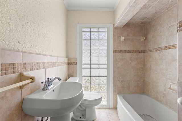 106 13th Ave, St Pete Beach, FL 33706 - bathroom featuring a textured wall, tile walls, ornamental molding, and tile patterned flooring