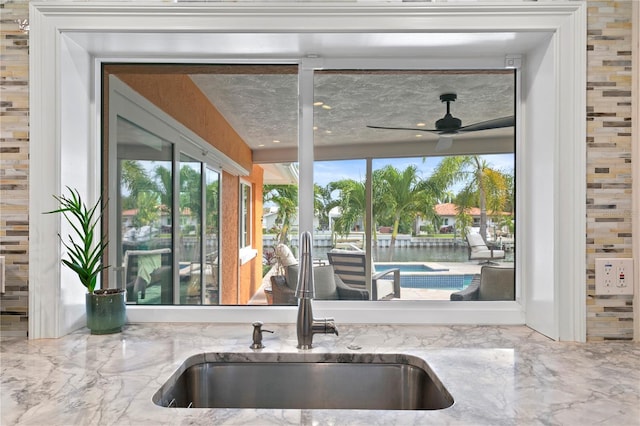 1960 Montana Ave NE, Saint Petersburg, FL 33703 - kitchen with a sink, light stone counters, a ceiling fan, and plenty of natural light