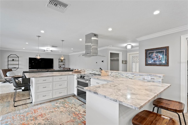 1960 Montana Ave NE, Saint Petersburg, FL 33703 - kitchen with exhaust hood, double oven range, a breakfast bar, light wood finished floors, and white cabinetry