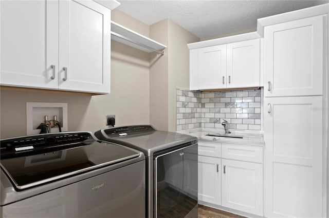 1960 Montana Ave NE, Saint Petersburg, FL 33703 - clothes washing area with washer and dryer, cabinet space, and a textured ceiling