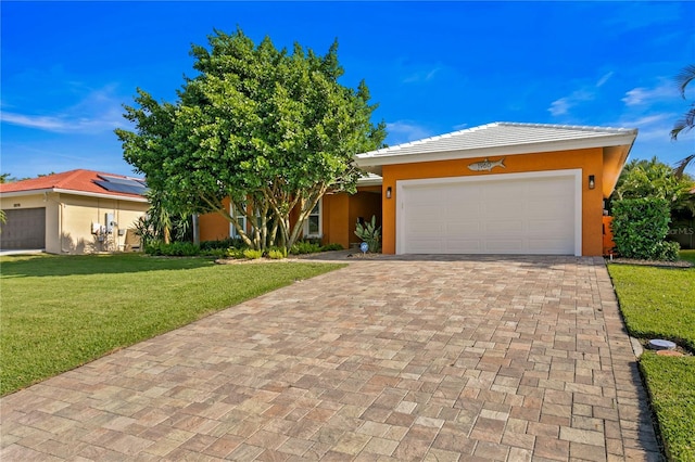 1960 Montana Ave NE, Saint Petersburg, FL 33703 - view of front facade with a front lawn, stucco siding, an attached garage, decorative driveway, and a tiled roof