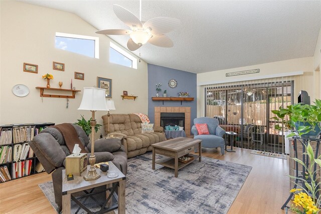 640 Lake Dexter Cir, Winter Haven, FL 33884 - living area featuring vaulted ceiling, a ceiling fan, wood finished floors, a tile fireplace, and a textured ceiling