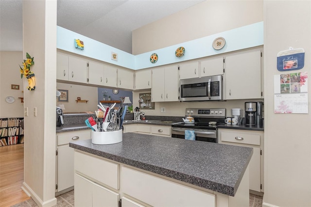 640 Lake Dexter Cir, Winter Haven, FL 33884 - kitchen featuring appliances with stainless steel finishes, dark countertops, a center island, and baseboards