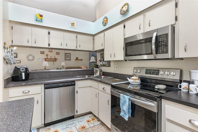 640 Lake Dexter Cir, Winter Haven, FL 33884 - kitchen featuring stainless steel appliances, a sink, dark countertops, and light tile patterned floors