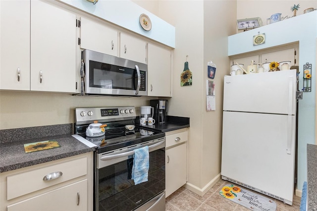 640 Lake Dexter Cir, Winter Haven, FL 33884 - kitchen with appliances with stainless steel finishes, dark countertops, baseboards, and light tile patterned flooring
