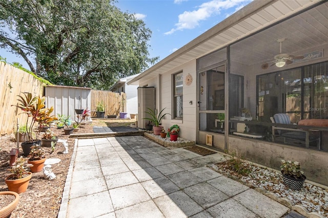 640 Lake Dexter Cir, Winter Haven, FL 33884 - view of patio / terrace featuring a ceiling fan, a sunroom, a shed, a fenced backyard, and an outdoor structure