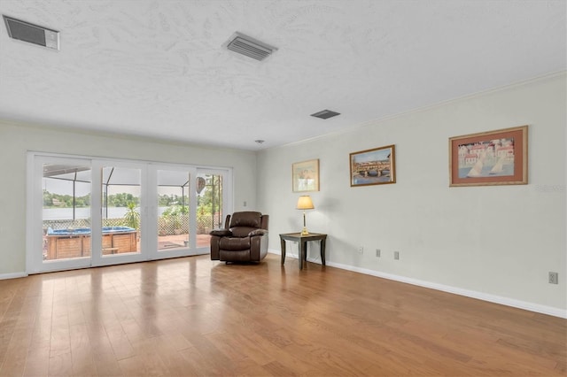 13533 Bay Lake Ln, Tampa, FL 33618 - living area featuring a textured ceiling, wood finished floors, ornamental molding, and baseboards