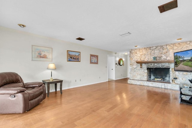 13533 Bay Lake Ln, Tampa, FL 33618 - living room with wood finished floors, ornamental molding, a stone fireplace, and baseboards
