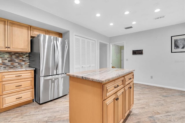 13533 Bay Lake Ln, Tampa, FL 33618 - kitchen with freestanding refrigerator, light wood-style flooring, recessed lighting, backsplash, and light stone countertops