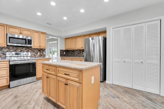 13533 Bay Lake Ln, Tampa, FL 33618 - kitchen with stainless steel appliances, light wood finished floors, decorative backsplash, a kitchen island, and recessed lighting