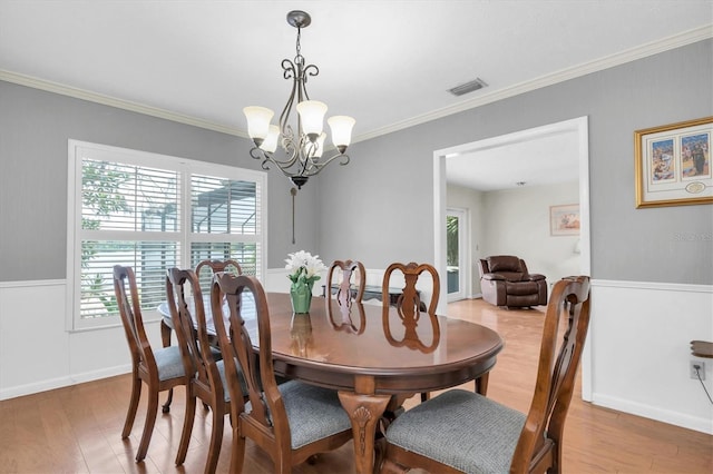 13533 Bay Lake Ln, Tampa, FL 33618 - dining space featuring light wood-style floors, crown molding, a chandelier, and baseboards