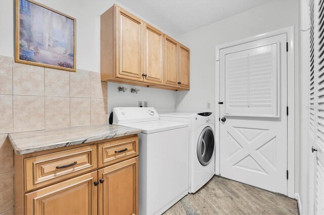 13533 Bay Lake Ln, Tampa, FL 33618 - laundry area with cabinet space, washer and clothes dryer, and light wood-style floors