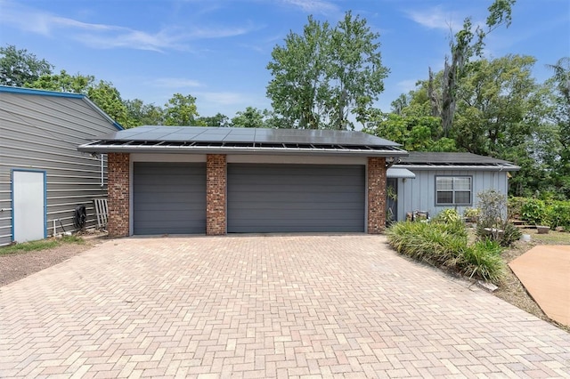 13533 Bay Lake Ln, Tampa, FL 33618 - garage featuring decorative driveway and solar panels