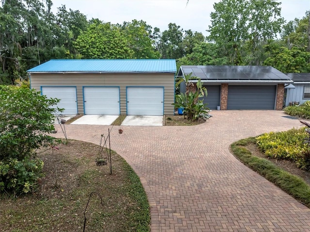13533 Bay Lake Ln, Tampa, FL 33618 - view of front of property with metal roof, an outdoor structure, and solar panels