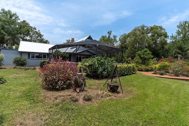 13533 Bay Lake Ln, Tampa, FL 33618 - back of property featuring a yard, a lanai, metal roof, and a chimney