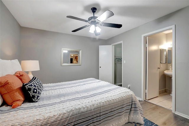 1400 Gandy Blvd N Unit 1504, Saint Petersburg, FL 33702 - bedroom featuring light wood-style flooring, ensuite bathroom, a ceiling fan, baseboards, and a walk in closet
