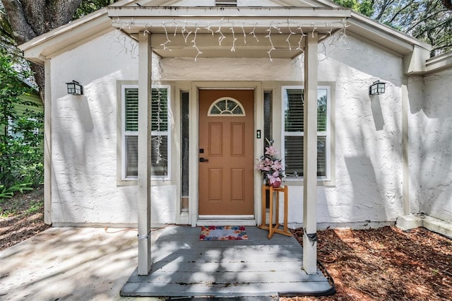 view of exterior entry featuring stucco siding