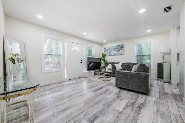 living room with light wood-style floors, baseboards, and recessed lighting
