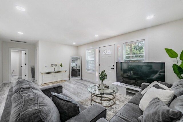 living area with wood finished floors, recessed lighting, and baseboards