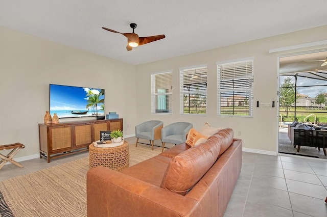 living room with ceiling fan, light tile patterned floors, and baseboards