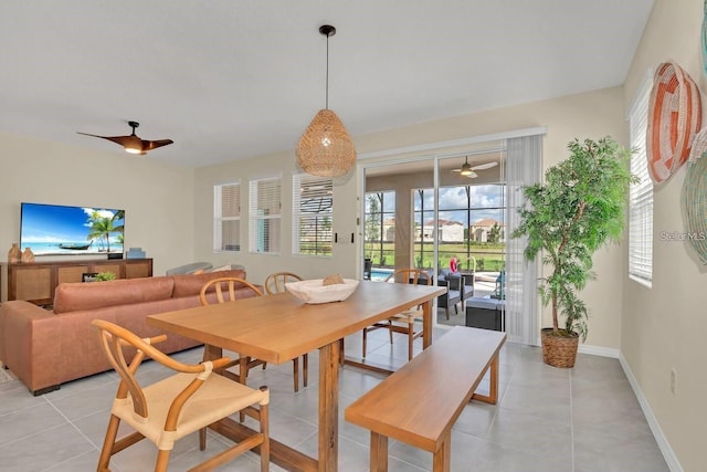 dining space featuring ceiling fan, light tile patterned floors, and baseboards