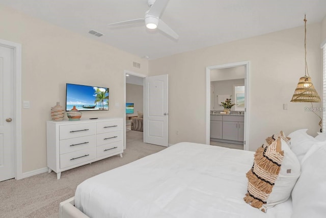 bedroom with light carpet, ensuite bath, baseboards, and ceiling fan
