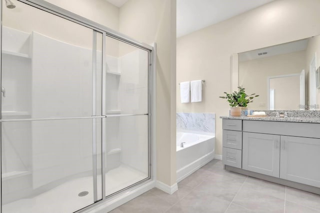 bathroom featuring a shower stall, tile patterned flooring, a garden tub, and baseboards