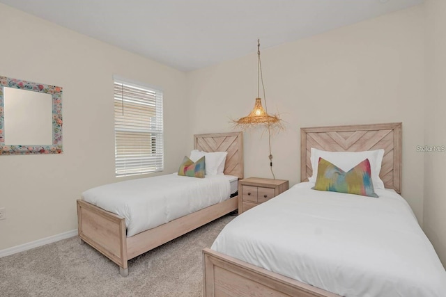 bedroom featuring light colored carpet and baseboards