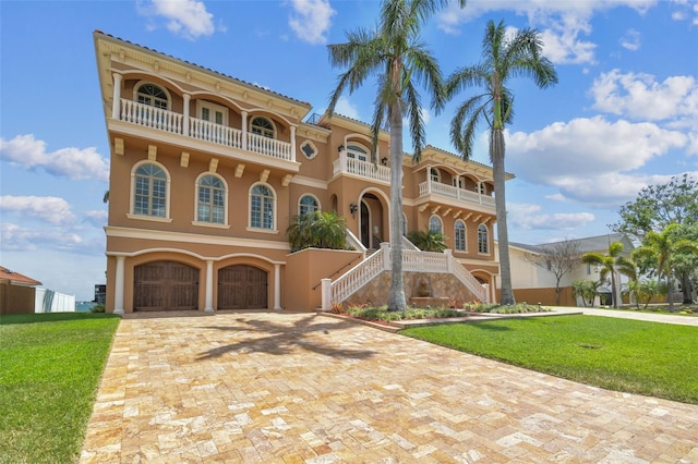 5810 Mariner St, Tampa, FL 33609 - mediterranean / spanish-style home with a balcony, stairway, stucco siding, and a front lawn