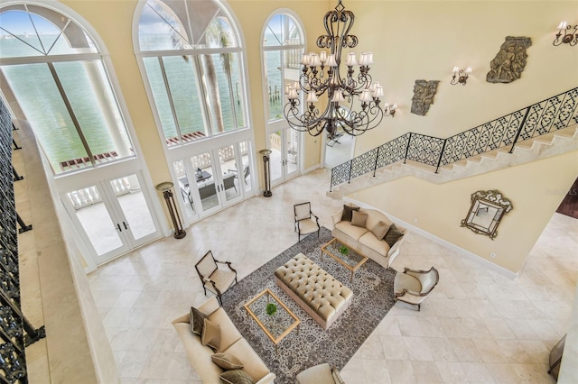 5810 Mariner St, Tampa, FL 33609 - living room featuring french doors, a towering ceiling, stairs, a chandelier, and tile patterned floors