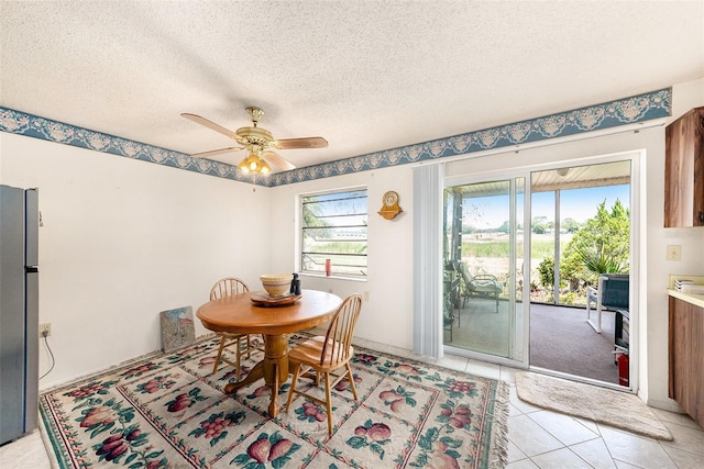 8305 Palencia Dr, Port Richey, FL 34668 - dining area featuring a ceiling fan, light tile patterned flooring, and a textured ceiling