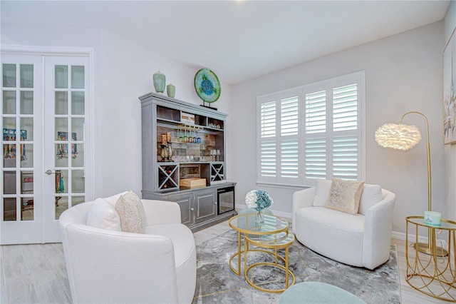 living area with french doors, wood finished floors, and baseboards