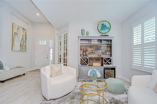 living room with baseboards, a dry bar, wood finished floors, and recessed lighting