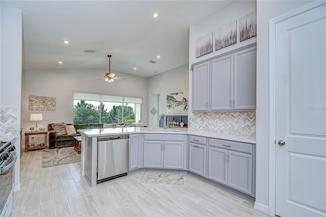 kitchen featuring appliances with stainless steel finishes, a sink, a peninsula, ceiling fan, and open floor plan