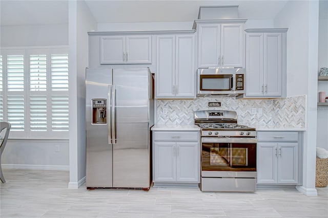 kitchen with appliances with stainless steel finishes, healthy amount of natural light, and backsplash