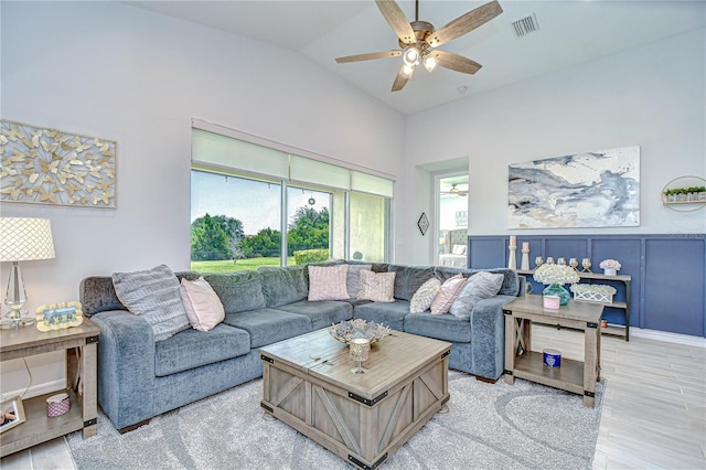 living room featuring ceiling fan, light wood-style floors, and lofted ceiling