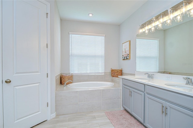 bathroom with a bath and double vanity