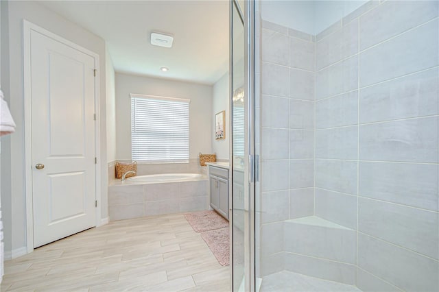 bathroom featuring a stall shower, a garden tub, and wood finished floors
