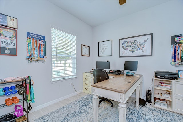office space featuring light wood-type flooring, baseboards, and a ceiling fan