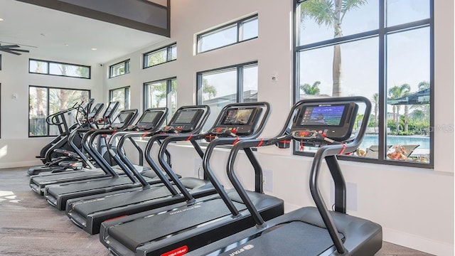 workout area featuring baseboards, recessed lighting, and a towering ceiling