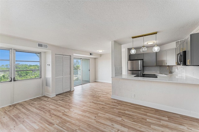 3315 58th Ave S Unit 605, Saint Petersburg, FL 33712 - kitchen featuring appliances with stainless steel finishes, gray cabinets, light wood-style flooring, light countertops, and a textured ceiling